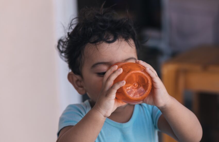 drink water in an orange glass outside the house